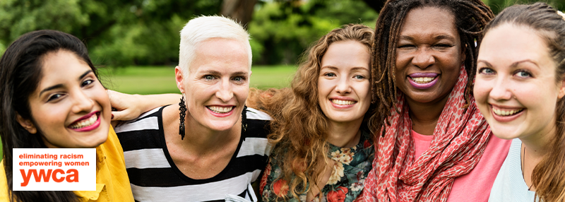 Five women with arms around each other's shoulders posing close up