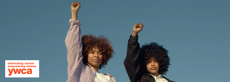 Two African American women raising their fists up in the air