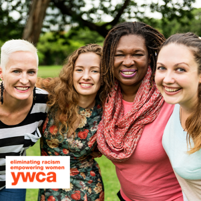 Five women with arms around each other's shoulders posing close up